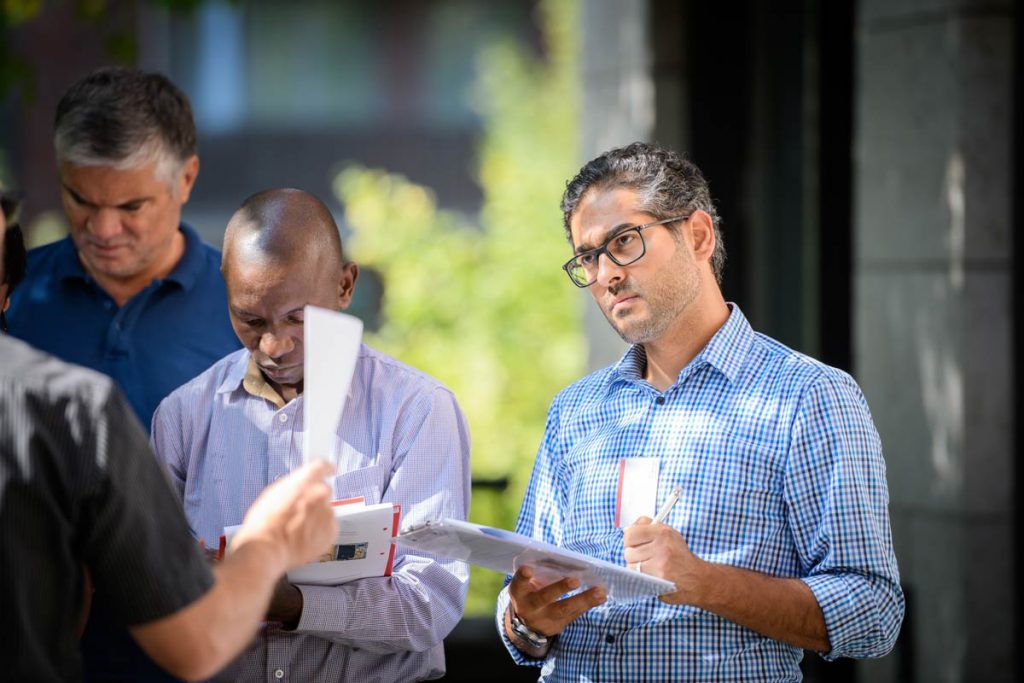 Students taking notes standing outside