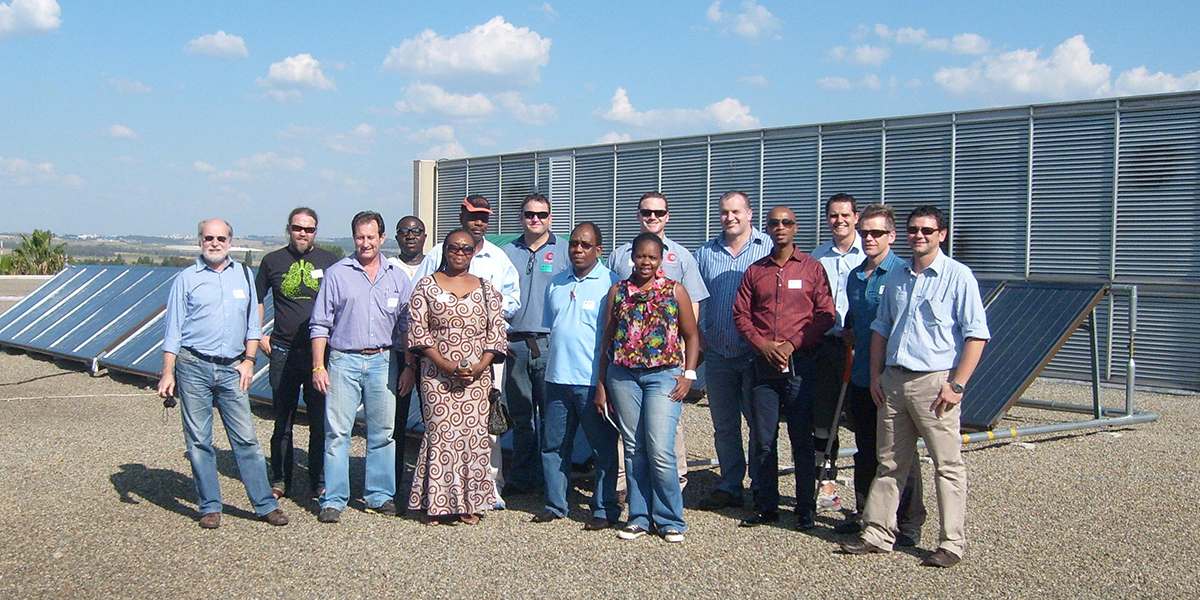 Group of students standing in front of solar panels