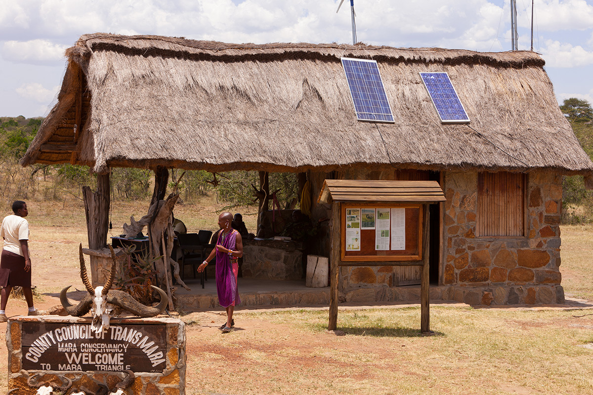 Trans Mara, Kenya - March 04, 2011: The border check-point between the Kenya counties of Trans Mara and Masai Mara; just a thatched roof and basic building creates the border post. A Masai tribesman can be seen in the foreground.