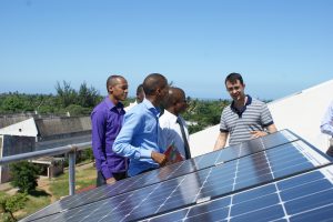 Men on a rooftop analyzing a solar panel