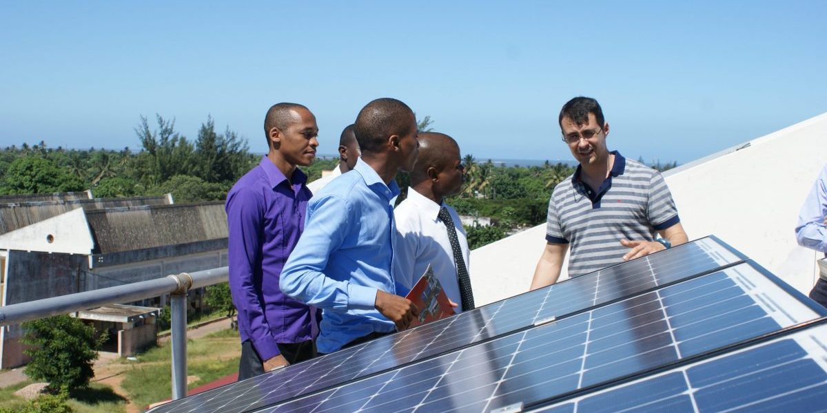 Men on a rooftop analyzing a solar panel