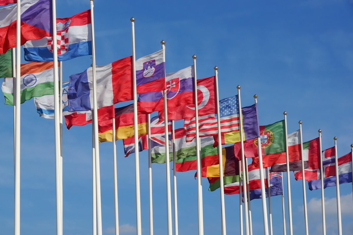 World Flags Blowing In The Wind On The Cloudy Sky Background