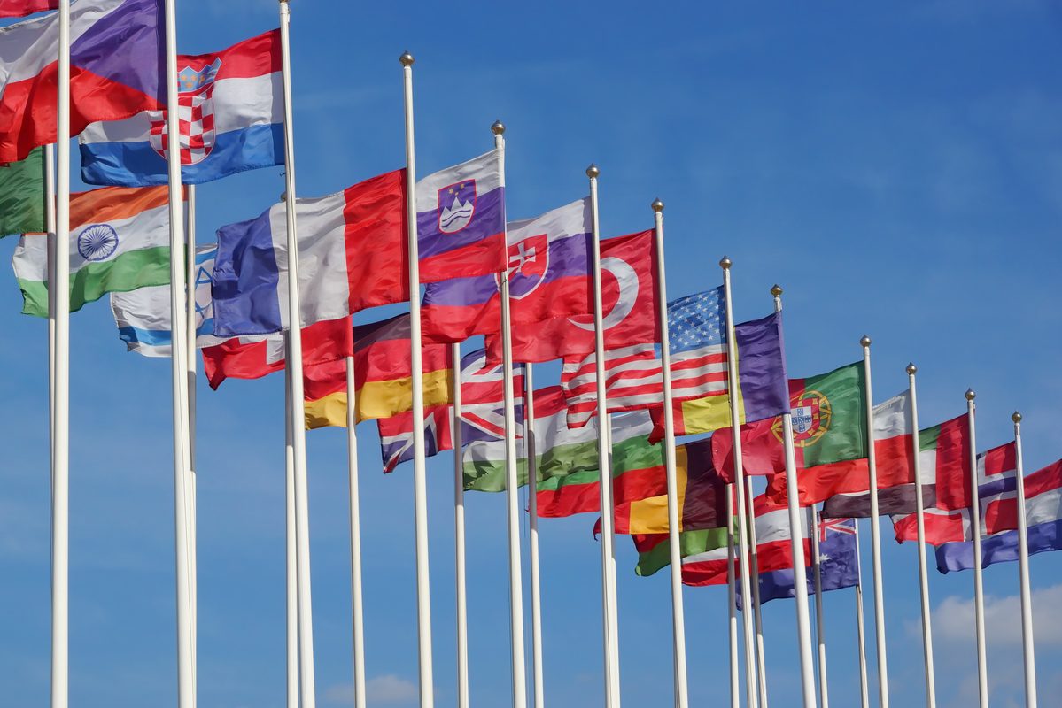 World Flags Blowing In The Wind On The Cloudy Sky Background