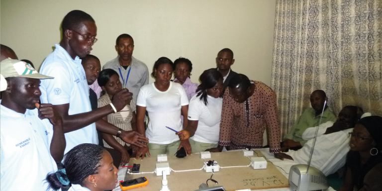 Group of students around of an electric device.