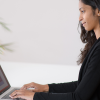 Woman writing in a laptop